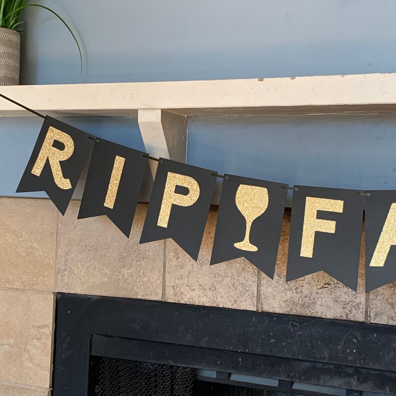 May include: Black and gold banner with the words "RIP" and a wine glass graphic, followed by the word "FA"