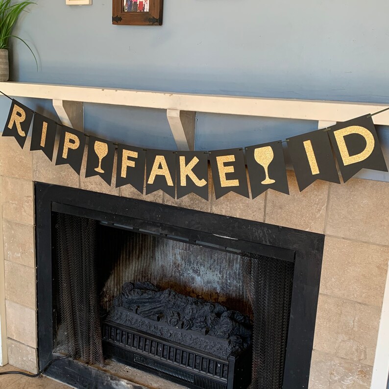 May include: Black and gold banner with the text "RIP FAKE ID" and a wine glass icon between the words "RIP" and "FAKE".