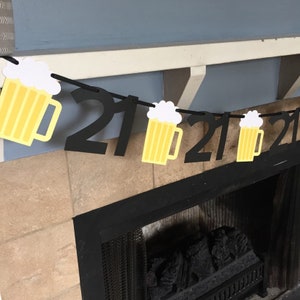 Pu&ograve; includere: Striscione di compleanno 21 anni nero e giallo con ritagli di boccali di birra. Lo striscione &egrave; infilato su uno spago nero e il numero 21 &egrave; ripetuto tre volte.