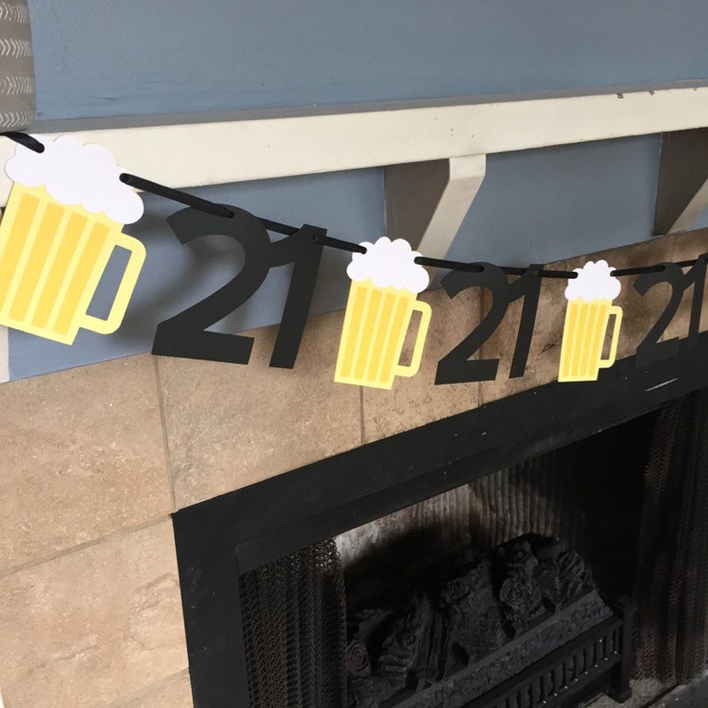 Pu&ograve; includere: Striscione di compleanno 21 anni nero e giallo con ritagli di boccali di birra. Lo striscione &egrave; infilato su uno spago nero e il numero 21 &egrave; ripetuto tre volte.