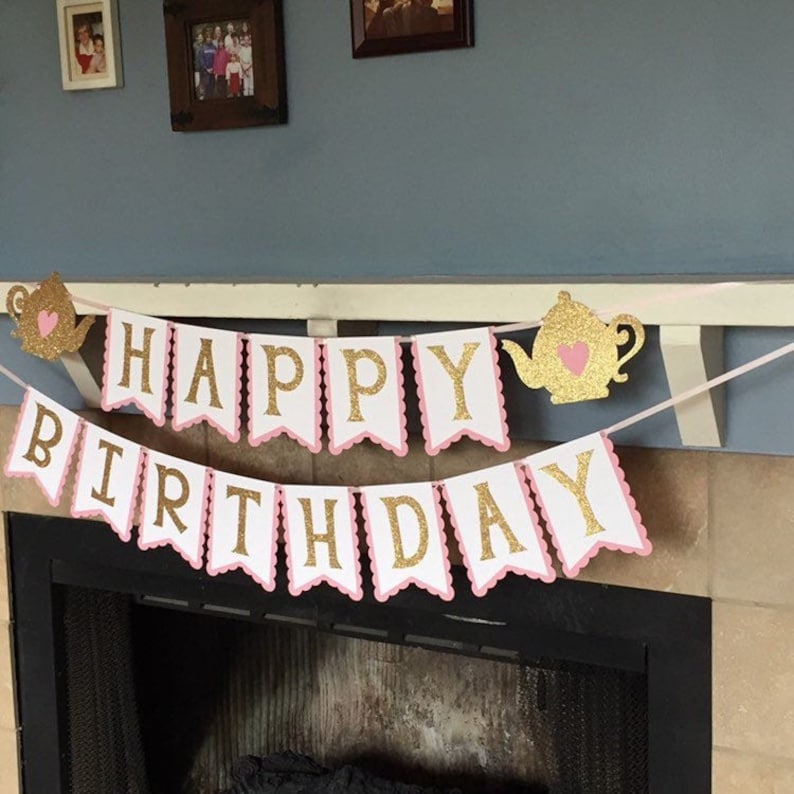 May include: A pink and gold "Happy Birthday" banner with teapots on each end. The banner is made of cardstock and has a scalloped edge.