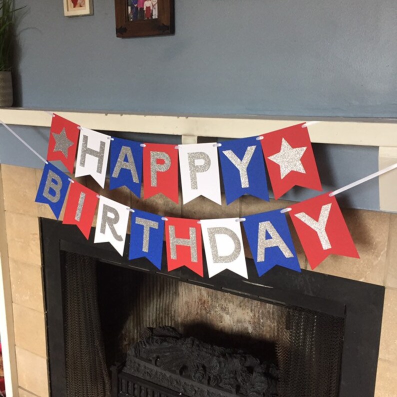 Puede incluir: Bandera roja, blanca y azul con letras de purpurina plateada que dice "Happy Birthday".