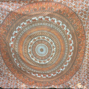 May include: A tapestry with a circular mandala design featuring elephants and intricate patterns in shades of orange, brown, and white.