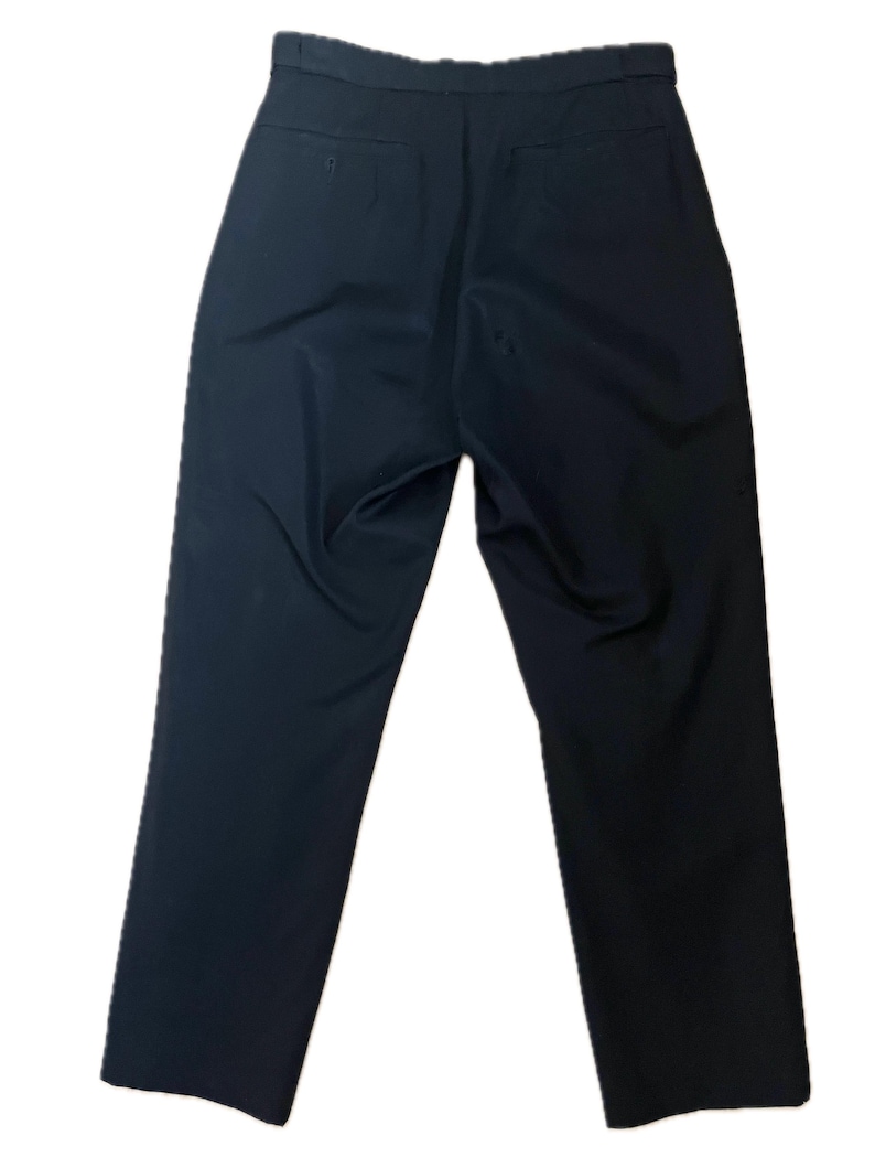 May include: A pair of navy blue trousers, viewed from the back. The pants have a straight leg design and feature two back pockets. The fabric appears smooth and wrinkle-free, suggesting a tailored fit. The trousers are suitable for various occasions.