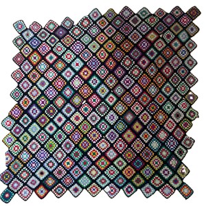 May include: A handmade crochet blanket composed of numerous small, square granny squares joined together. Each square features a vibrant, multi-colored center surrounded by a black border, creating a distinct grid pattern across the entire piece.