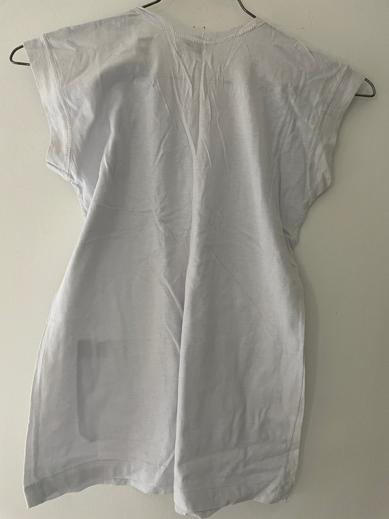 May include: A white, short-sleeved t-shirt with a crew neck.