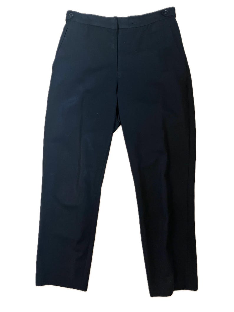 May include: A pair of black trousers with a button closure and pockets. The pants have a straight leg design and are made of a solid, dark fabric. The trousers are suitable for various occasions.