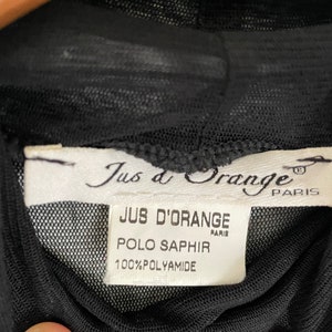 May include: Black sheer top with a white label that reads "Jus d'Orange Paris" and "Jus d'Orange Paris Polo Saphir 100% Polyamide".