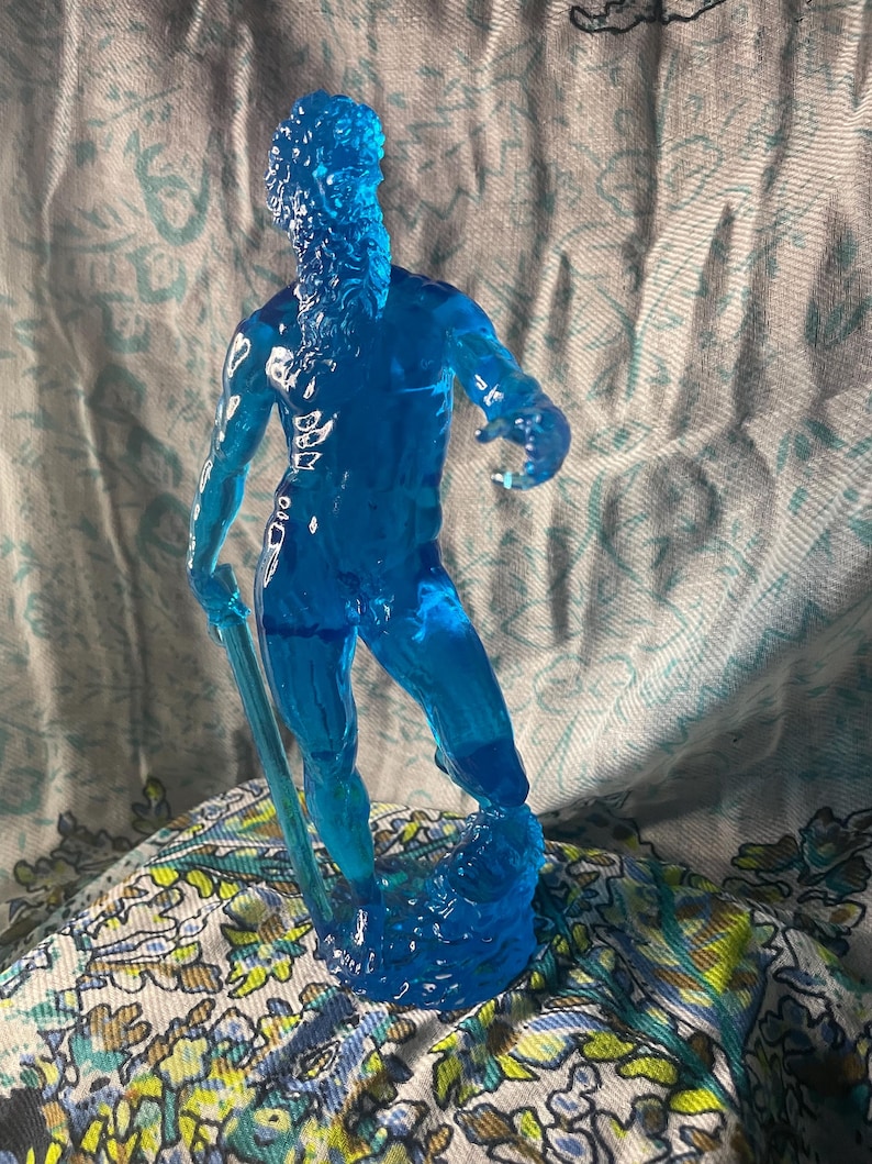 K&ouml;nnte beinhalten: Eine durchscheinende blaue Figur eines Mannes mit langem Bart, der einen Stab h&auml;lt. Die Figur steht auf einem strukturierten Sockel. Die Figur besteht aus einem klaren, gl&auml;nzenden Material.