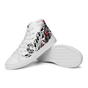 May include: White high-top canvas sneakers with a black and red design featuring stylized figures and floral patterns.
