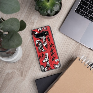 Könnte beinhalten: Eine transparente Handyhülle mit rotem Hintergrund und schwarz-weißem Design. Das Design zeigt einen stilisierten Vogel, Blumen und geometrische Muster.