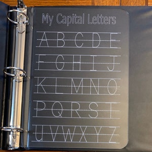 May include: A clear plastic sheet with the title "My Capital Letters" printed at the top. The sheet has lines for tracing the capital letters of the alphabet, A through Z.