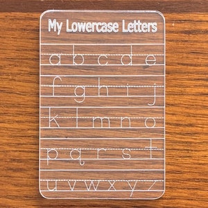 May include: A clear plastic card with the text "My Lowercase Letters" at the top. The card has lines with lowercase letters printed on them, including a, b, c, d, e, f, g, h, i, j, k, l, m, n, o, p, q, r, s, t, u, v, w, x, y, and z.