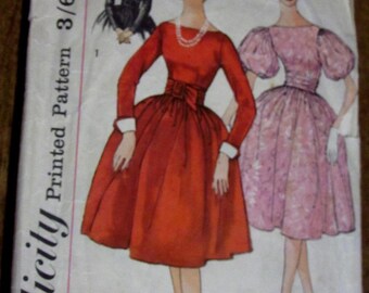 May include: Simplicity Printed Pattern 3/8, sewing pattern number 3150, size 14, bust 34, featuring three women wearing dresses. The woman on the left is wearing a black dress, the woman in the center is wearing a red dress with a bow, and the woman on the right is wearing a pink dress with puffed sleeves.