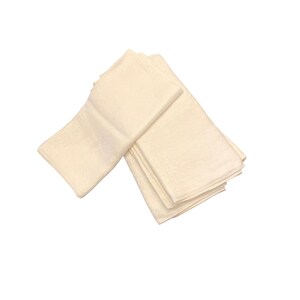 May include: A stack of off-white cloth napkins, folded and arranged. The napkins have a subtle, textured pattern. The image is taken against a white background, highlighting the napkins' color and texture. Ideal for home decor or special events.