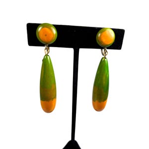 May include: A white ceramic mug with a black handle and the text "But First, Coffee" in a black, handwritten-style font. The mug is on a white surface.