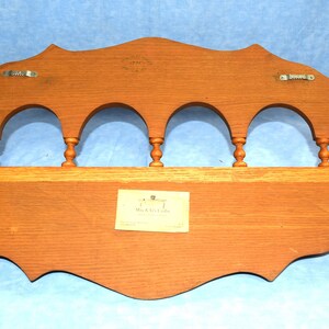 May include: A wooden wall shelf with a scalloped edge and five arches. The shelf has a label that reads "J.T. Beaulieu Co."