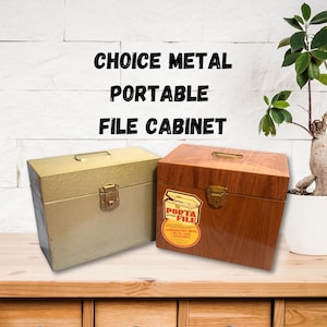 May include: Two metal file cabinets, one with a woodgrain finish and the other with a light green finish. Both cabinets have a brass latch and a label that says "Porta File".