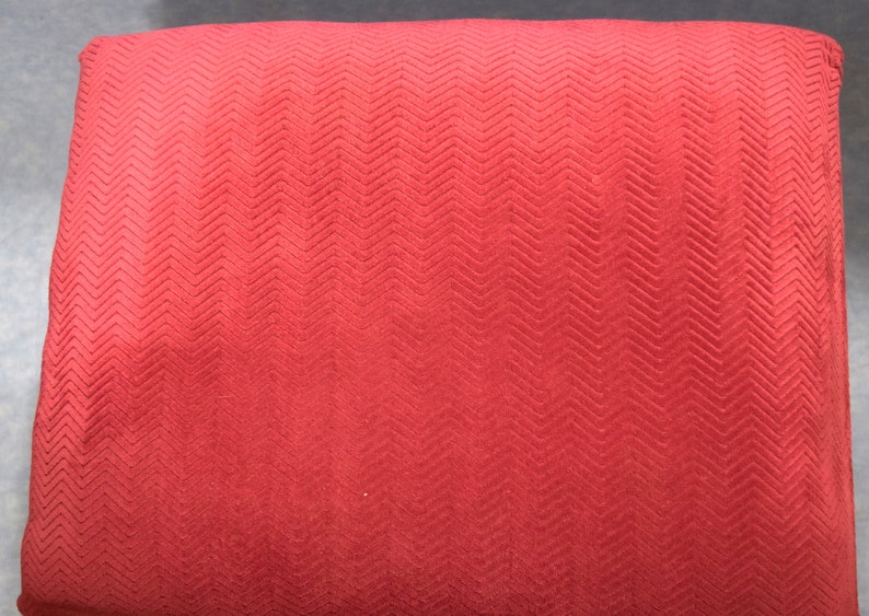 May include: Red fabric with a chevron pattern. The fabric has a soft, textured surface.