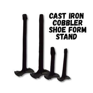May include: Four black cast iron cobbler shoe form stands of varying heights are displayed against a white background. The stands have a T-shaped base and a vertical post. The text "CAST IRON COBBLER SHOE FORM STAND" is printed in black.