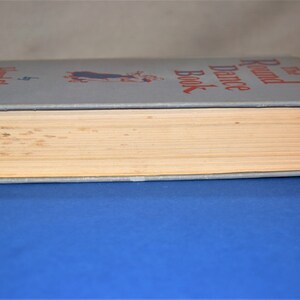 May include: The Round Dance Book by  Eleanor  Selfridge. The book has a blue cover with a red title and a black and white illustration of a couple dancing.