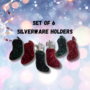 May include: A set of six decorative silverware holders shaped like Christmas stockings. The holders are in green and red with gold trim, and each holds a fork, knife, and spoon. The text "SET OF 6 SILVERWARE HOLDERS" is displayed.
