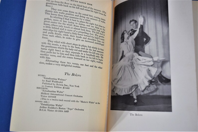 May include: A black and white photograph of a couple dancing the bolero. The woman is wearing a long, flowing skirt and the man is wearing a suit. The caption below the image reads "The Bolero."