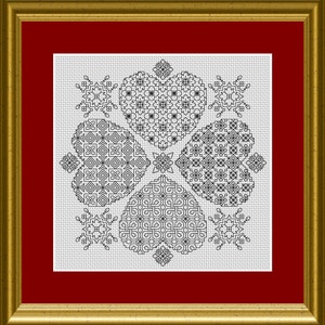 May include: Cross-stitch artwork featuring four heart shapes with intricate black and white geometric patterns. The artwork is framed in a gold-colored frame with a red matting.