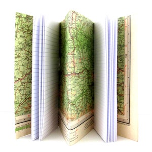 May include: A notebook with a green map design on the cover. The notebook is open and the pages are lined.