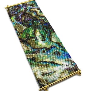 K&ouml;nnte beinhalten: Ein Armband aus Perlen mit einem farbenfrohen, abstrakten Muster. Das Armband besteht aus kleinen, schillernden Perlen und hat einen goldenen Metallverschluss.
