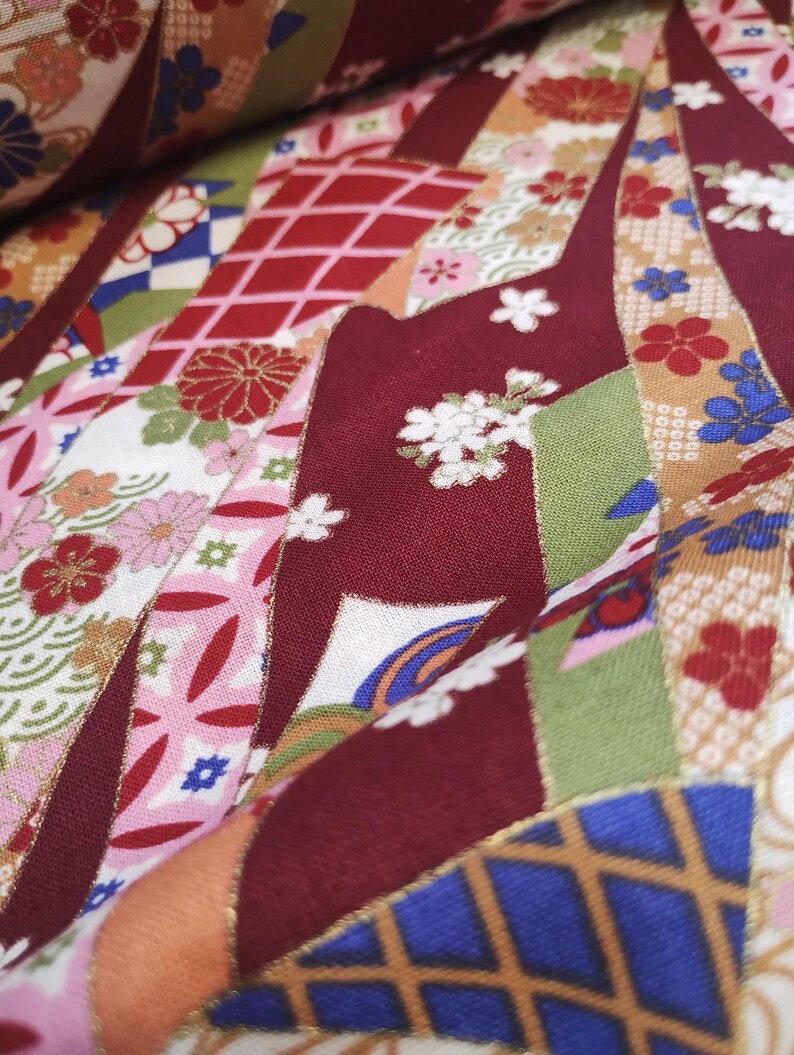 May include: Red, green and gold fabric with a Japanese-inspired pattern of flowers, geometric shapes and stylised waves.
