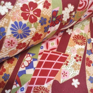 May include: Red, white and gold fabric with a Japanese-inspired floral pattern. The fabric features a repeating design of flowers, geometric shapes and a wave pattern.
