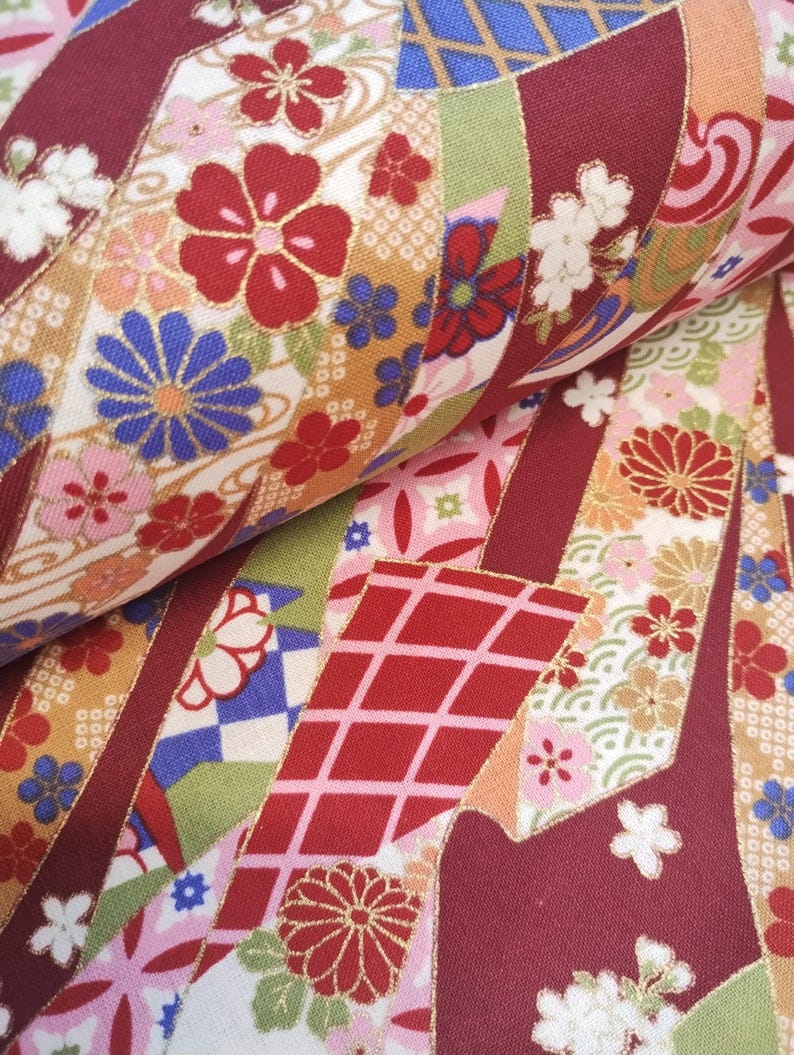 May include: Red, white and gold fabric with a Japanese-inspired floral pattern. The fabric features a repeating design of flowers, geometric shapes and a wave pattern.