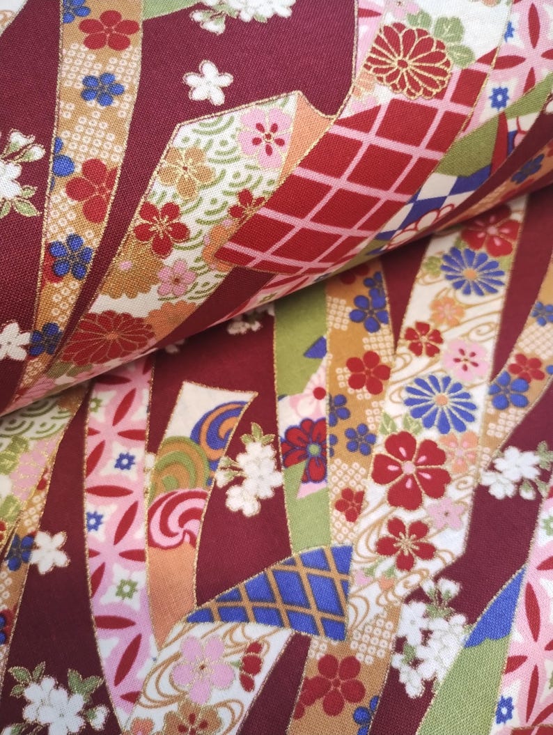 May include: Red fabric with a repeating pattern of gold, blue, and pink ribbons with floral designs. The fabric has a traditional Japanese aesthetic.