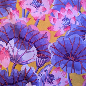 Può includere: Un vivace motivo floreale con fiori di loto e foglie stilizzate. Il design presenta fiori rosa e viola con baccelli di semi dettagliati su uno sfondo giallo dorato. Le foglie sono viola scuro con venature rosse.