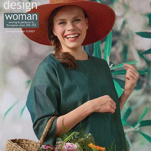 May include: OTTOBRE design woman magazine cover. A woman wearing a wide-brimmed orange hat and a green dress smiles. The cover includes text: "sewing & patterns in European sizes 34-52" and "Spring/Summer 2/2021". A woven basket with flowers is in the foreground.