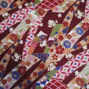 May include: Red fabric with a colourful Japanese-inspired pattern. The fabric features a variety of geometric shapes, flowers, and waves. The fabric is perfect for quilting, sewing, and crafting.