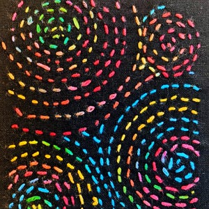 Pode incluir: Bordado costurado à mão em tecido preto. O design apresenta quatro padrões giratórios, cada um preenchido com pontos coloridos e curtos em um arco-íris de tons. As linhas vibrantes criam uma obra de arte abstrata e texturizada.