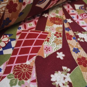 May include: Close-up of a fabric with a colourful Japanese-inspired pattern. The fabric features a variety of flowers, geometric shapes, and gold accents. The fabric is a mix of red, pink, white, green, and gold.