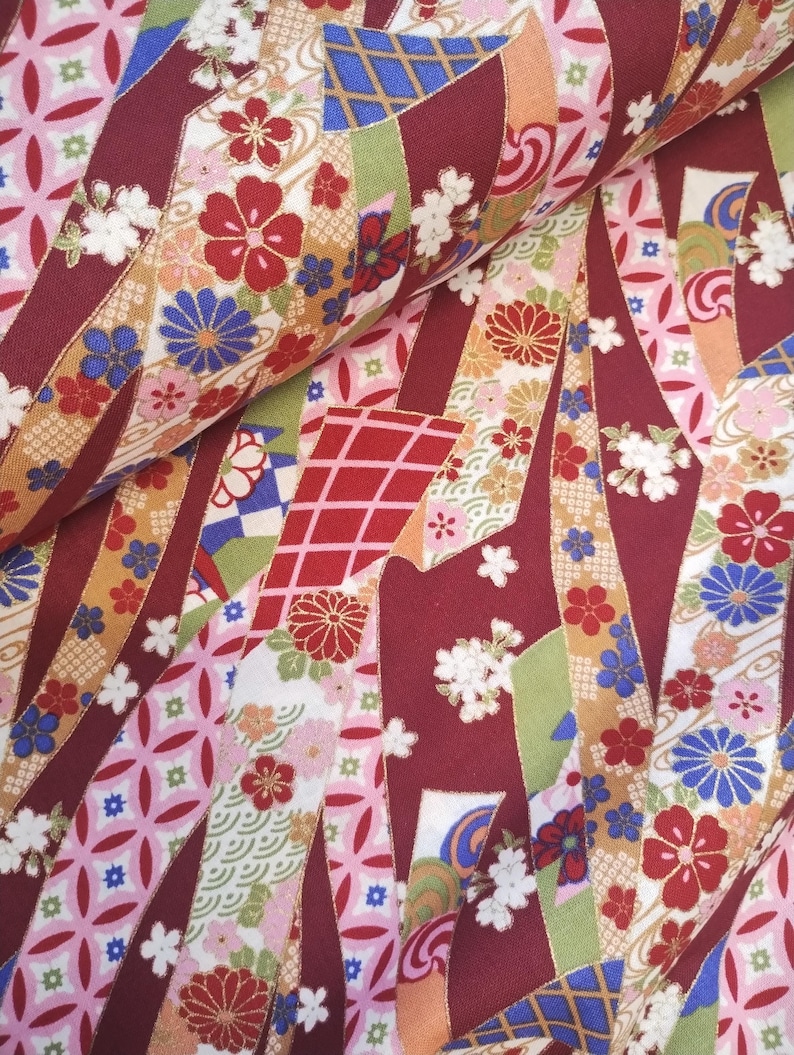 May include: Red, pink, blue and gold patterned fabric with a Japanese-inspired design. The fabric features a variety of floral motifs, geometric shapes and traditional Japanese patterns.