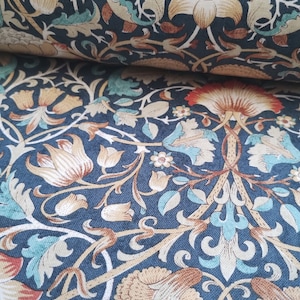 Könnte beinhalten: Ein dunkelblauer Stoff mit einem sich wiederholenden Muster aus stilisierten Blumen und Blättern in Beige-, Braun- und Türkistönen.