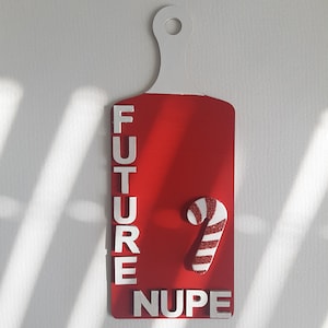 May include: Red wooden cutting board with white letters spelling "FUTURE NUPE" and a white and red candy cane.