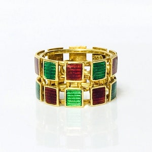May include: A gold ring with a geometric design featuring alternating red and green enamel squares.