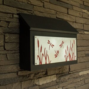 May include: A black metal mailbox with a silver metal panel featuring a red dragonfly and cattail design.