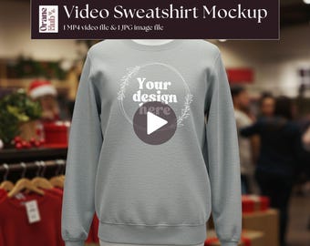May include: A light gray sweatshirt displayed on a mannequin. The sweatshirt has a round neckline and long sleeves. The text "Your design here" is displayed on the front, along with a play button. The image also includes the text "Video Sweatshirt Mockup".