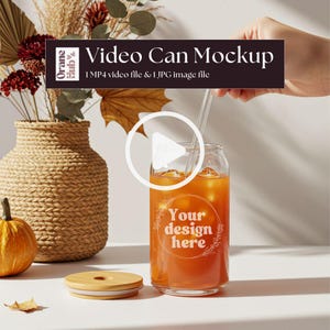 May include: A clear glass can-shaped mockup filled with an orange beverage and ice, with a straw. The can has the text "Your design here". A wooden lid sits beside the can. The image includes text that says "Video Can Mockup".