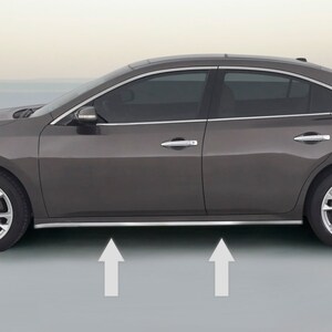 May include: A dark grey saloon with chrome trim along the bottom of the doors. The car is parked on a grey surface with white arrows pointing upwards.