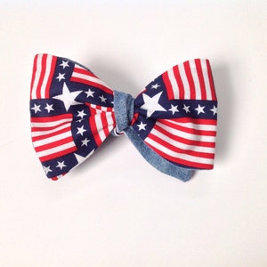 May include: A red, white, and blue bow tie with a denim center. The bow tie is patterned with stars and stripes.