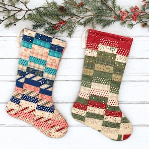 May include: Two quilted Christmas stockings featuring a patchwork design of rectangular fabric strips. The left stocking displays blue, teal, and cream patterns, while the right stocking features red, green, and cream holiday-themed fabric prints.