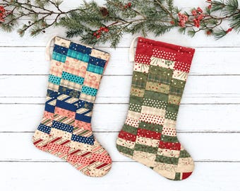 May include: Two quilted Christmas stockings featuring a patchwork design of rectangular fabric strips. The left stocking displays blue, teal, and cream patterns, while the right stocking features red, green, and cream holiday-themed fabric prints.